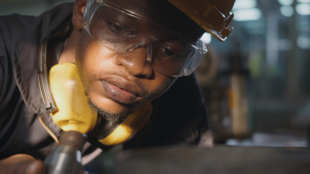 Engineer wearing hard hat inspecting work on the factory floor