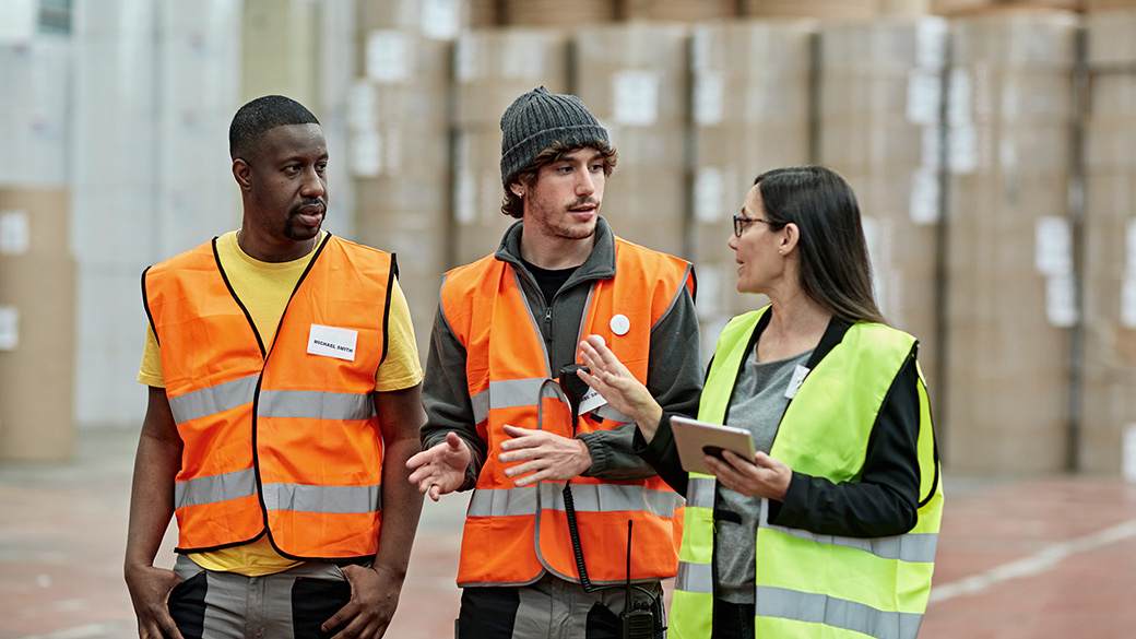 穿着反光背心的工人与主管一起讨论存储管理问题 穿着反光背心的工人与主管一起讨论存储管理问题